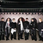 BTS poses in front of Gyeongbokgung Gate in Seoul at night, dressed in all-black ensembles for their ARIRANG comeback concert.