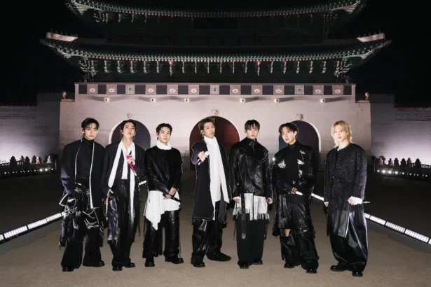 BTS poses in front of Gyeongbokgung Gate in Seoul at night, dressed in all-black ensembles for their ARIRANG comeback concert.