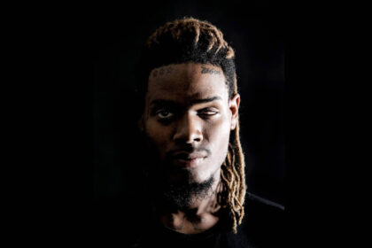 Fetty Wap in a dramatic dark portrait, looking introspective.