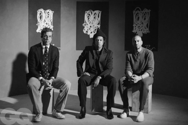 Jay-Z seated between two men in a black-and-white GQ photo shoot