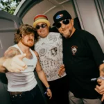 Three members of Sublime posing backstage at a live event.