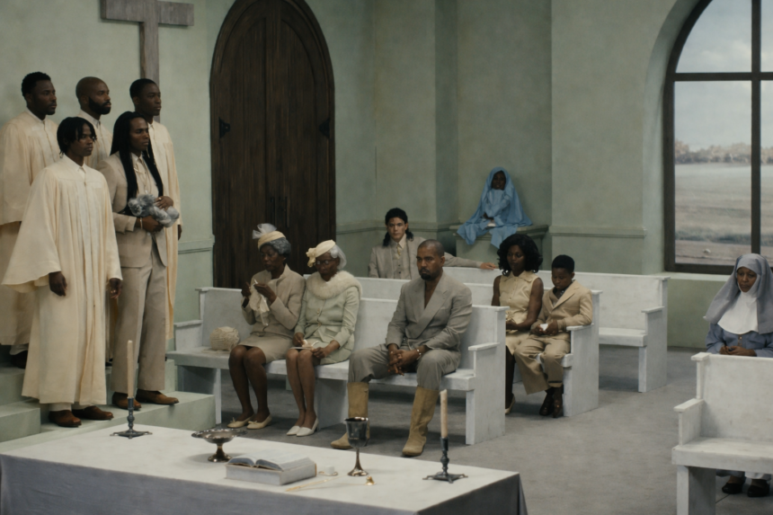 Ye sits in a church pew surrounded by congregation members in cream and white attire in the 'Father' music video