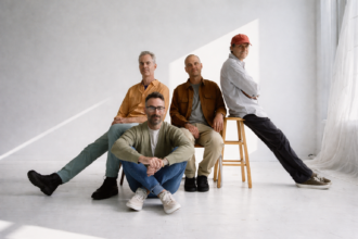 American Football pose in a bright white studio for their LP4 press photo, ahead of the album's May 1, 2026 release via Polyvinyl - LateTown