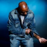 Chicago rapper Don Che in a press photo wearing a denim jacket and gold chain, promoting his new single Cover Charge from Tha Sauce Vol. 2 EP