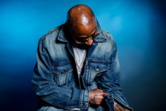 Chicago rapper Don Che in a press photo wearing a denim jacket and gold chain, promoting his new single Cover Charge from Tha Sauce Vol. 2 EP