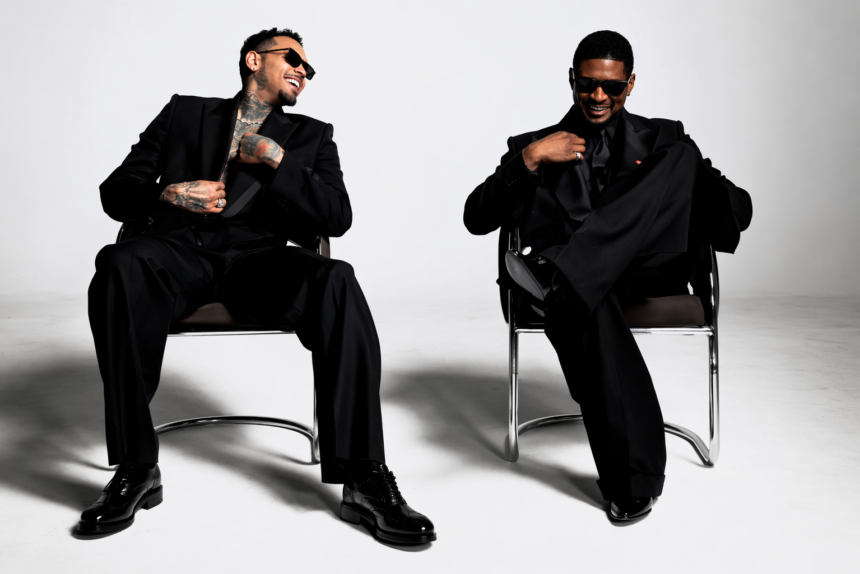 Chris Brown and Usher seated in chairs wearing black suits, laughing, R&B Tour 2026 press photo