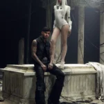 Futuristic scene from Bad Angel LISA stands in an ivory bodysuit above Anyma, set among ruined pillars and tangled cables, blending ancient and cyberpunk aesthetics.