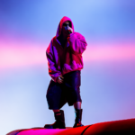 Justin Bieber performs at Coachella 2026 in an oversized pink hoodie under neon stage lights