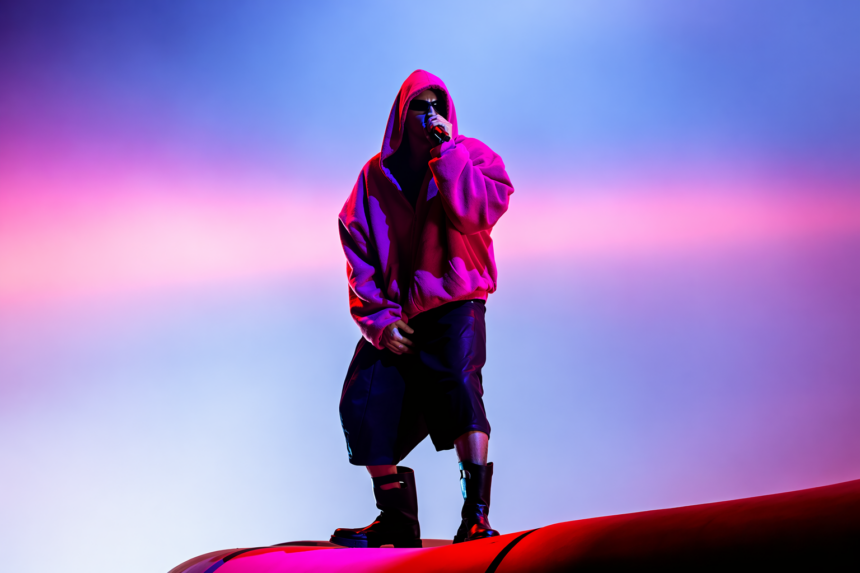 Justin Bieber performs at Coachella 2026 in an oversized pink hoodie under neon stage lights