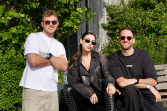 Lauren Mia and MAMI photographed together at a festival, the trio posing in front of a lush green wall