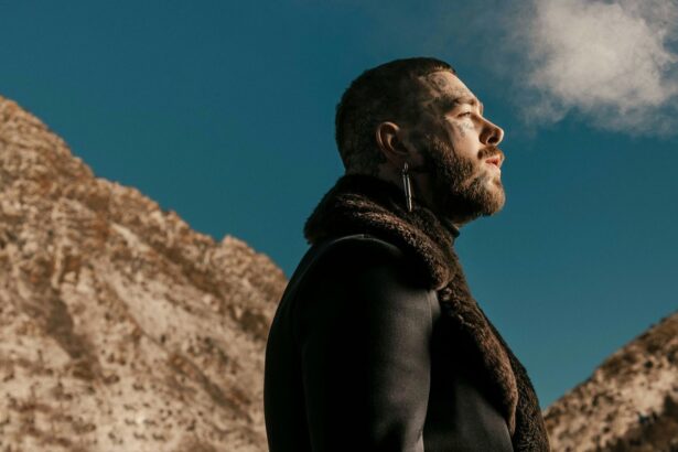 Post Malone in side profile against a rocky mountain backdrop and blue sky - LateTown jpg
