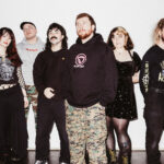 Sincere Engineer pose together against a white wall for a band promo photo ahead of their fourth album 'Probable Claws'