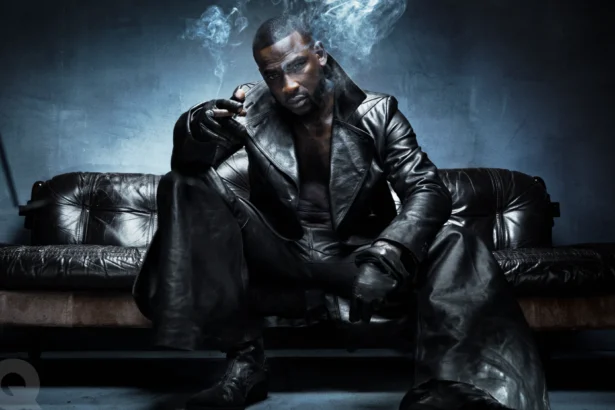 Skepta sits on a dark leather couch wearing an all-black leather outfit and gloves LateTown