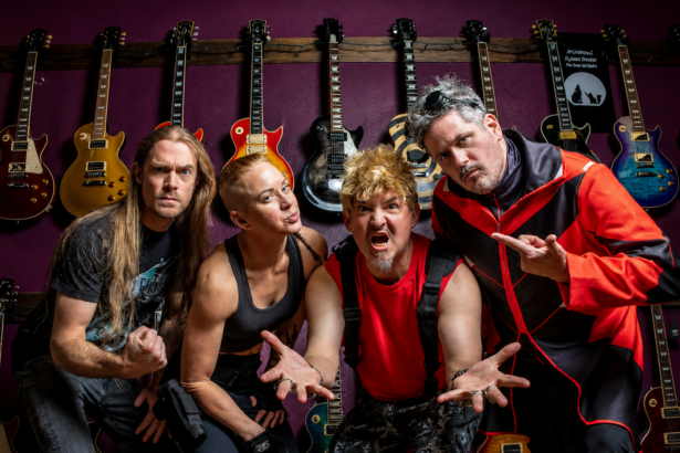 Chatrooms band posing in front of a wall of electric guitars, wearing casual rock outfits, with four members striking energetic poses.
