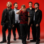 Nothing But Thieves pose against a bold red background in a 2026 press photo, ahead of their fifth studio album 'Stray Dogs' and biggest ever headline world tour.