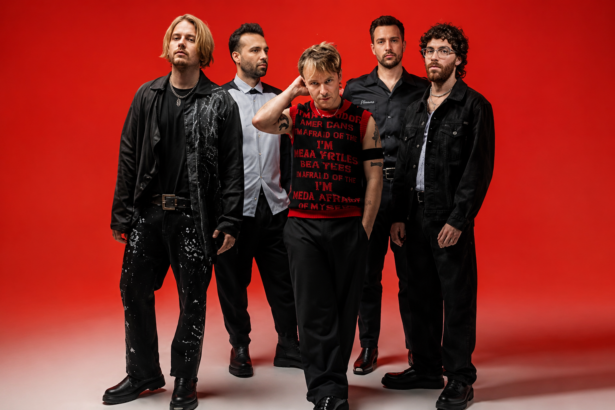 Nothing But Thieves pose against a bold red background in a 2026 press photo, ahead of their fifth studio album 'Stray Dogs' and biggest ever headline world tour.