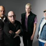 `Pixies photographed in a moody studio portrait against a grey background, featured as part of the Ohana Festival 2026 lineup announcement.`