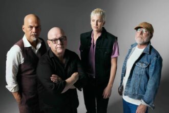 `Pixies photographed in a moody studio portrait against a grey background, featured as part of the Ohana Festival 2026 lineup announcement.`
