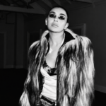 Promotional cover image for Perfect featuring Yella Yella in a black-and-white fashion-style portrait, wearing a dramatic fur coat with bold eye makeup in a dimly lit industrial setting.