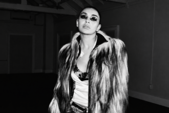 Promotional cover image for Perfect featuring Yella Yella in a black-and-white fashion-style portrait, wearing a dramatic fur coat with bold eye makeup in a dimly lit industrial setting.