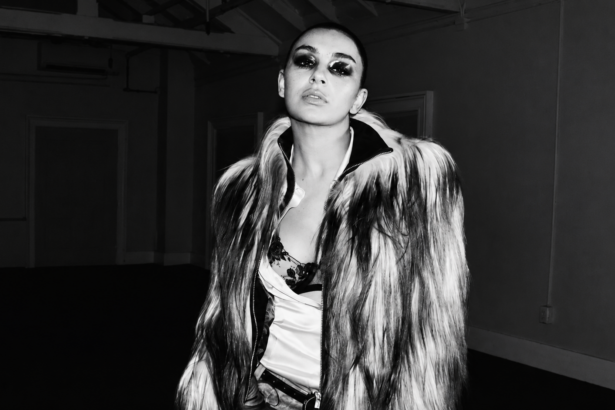 Promotional cover image for Perfect featuring Yella Yella in a black-and-white fashion-style portrait, wearing a dramatic fur coat with bold eye makeup in a dimly lit industrial setting.