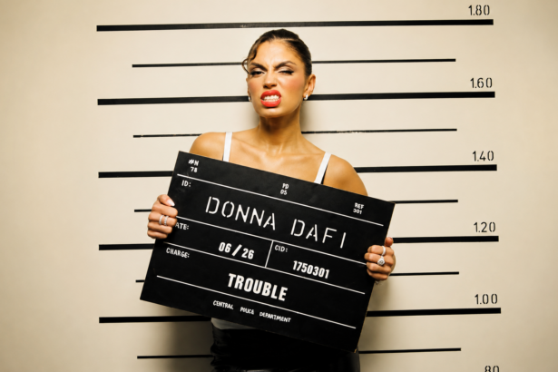 Donna Dafi official press photo for Trouble single Record17 2026 styled as mugshot police lineup themed cover art