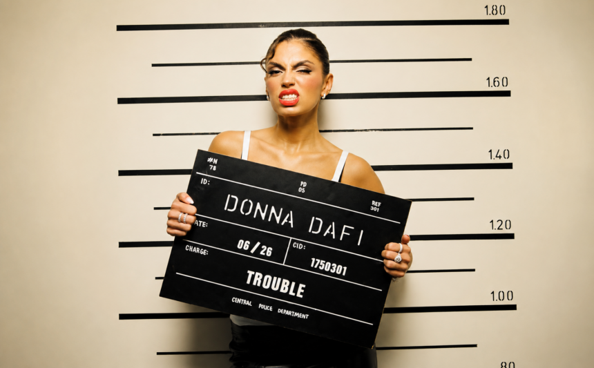Donna Dafi official press photo for Trouble single Record17 2026 styled as mugshot police lineup themed cover art