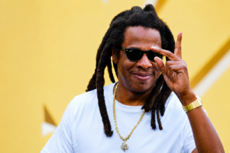 Jay-Z photographed in 2026 wearing white t-shirt and gold chain ahead of Reasonable Doubt 30th anniversary Paris and Los Angeles concerts