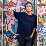 Johnny Marr official press photo for The Age Of Everything fifth solo album BMG October 2026 photographed against street art wall