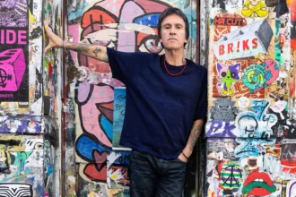 Johnny Marr official press photo for The Age Of Everything fifth solo album BMG October 2026 photographed against street art wall