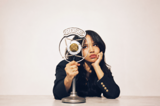 Baby Rose poses with a vintage Rose-branded microphone in a press photo for her album 'YEARNALISM'