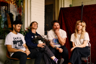 The four members of Atlanta indie rock band Ultra Lights sit together on a porch in a press photo for their debut album 'Pleasure's All Yours.'