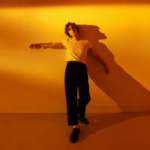 Alfie Jukes Brighton indie pop singer songwriter official press photo for Edges of You new single July 2026 Royal Shakespeare Company background