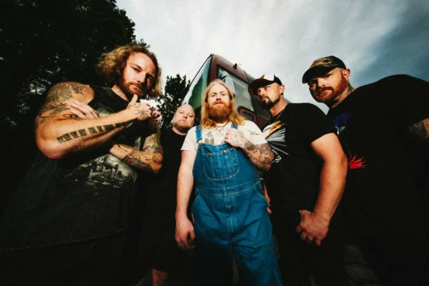 The five members of Texas hard rock band Blacktop Mojo stand in front of their tour bus in a press photo for the new single 'S.A.D.'