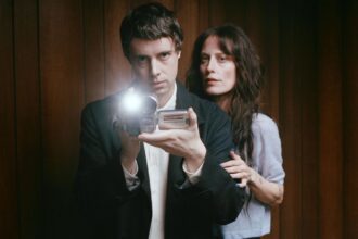 Boy Harsher's Augustus Muller and Jae Matthews pose with a vintage camcorder for their album Get Mean
