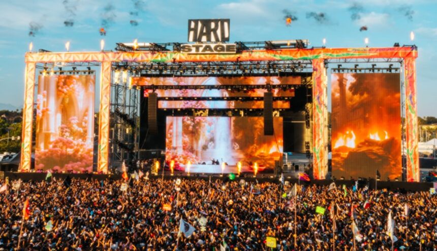 Massive crowd gathered at the HARD Stage during HARD Summer Music Festival, with pyrotechnics and giant LED screens lighting up the main stage at sunset