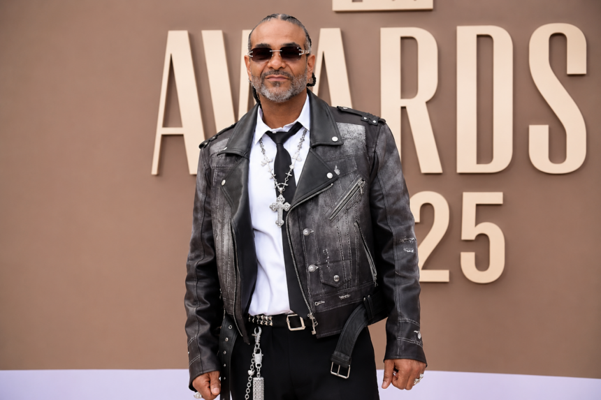 Jim Jones, who claims his catalog tops 90 percent of New York rappers, poses on the red carpet in a leather biker jacket, sunglasses, and cross chains at an awards show