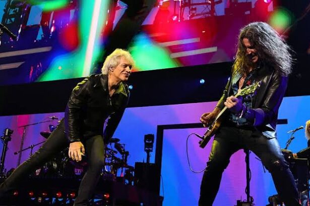 Jon Bon Jovi and guitarist Phil X perform onstage under colored lights during a Bon Jovi concert