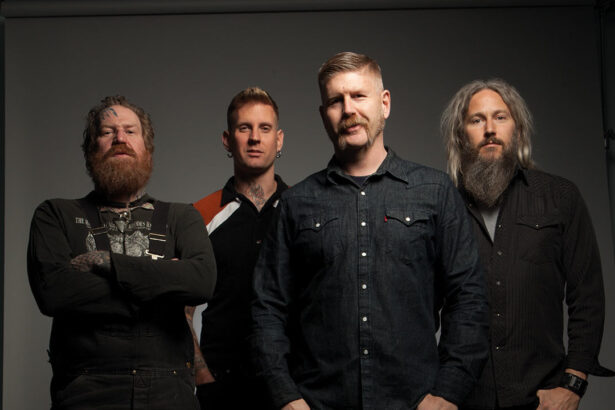 Mastodon band members pose for a studio portrait against a gray backdrop.
