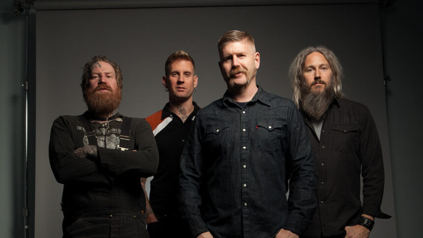 Mastodon band members pose for a studio portrait against a gray backdrop.