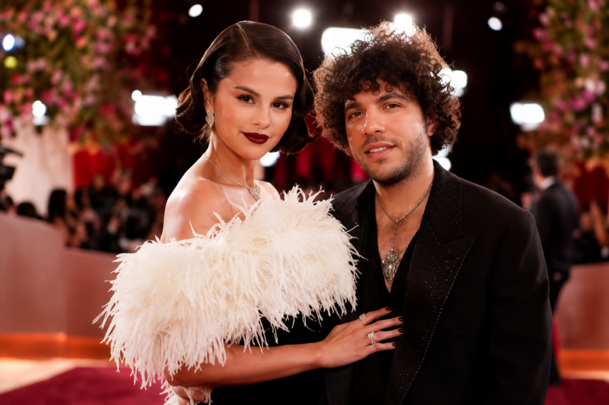 Selena Gomez and Benny Blanco pose together on a red carpet, Gomez in a white feathered dress
