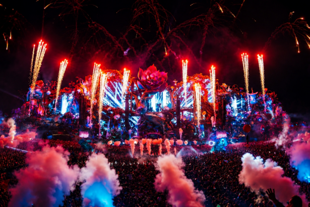 Tomorrowland's massive ornate Mainstage lights up at dusk with pyrotechnics and lasers as a huge crowd fills the Holy Grounds at De Schorre in Boom, Belgium.