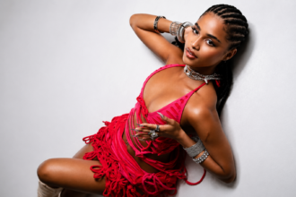 Tyla poses in a red fringed outfit and silver jewelry against a white backdrop for her album A*POP