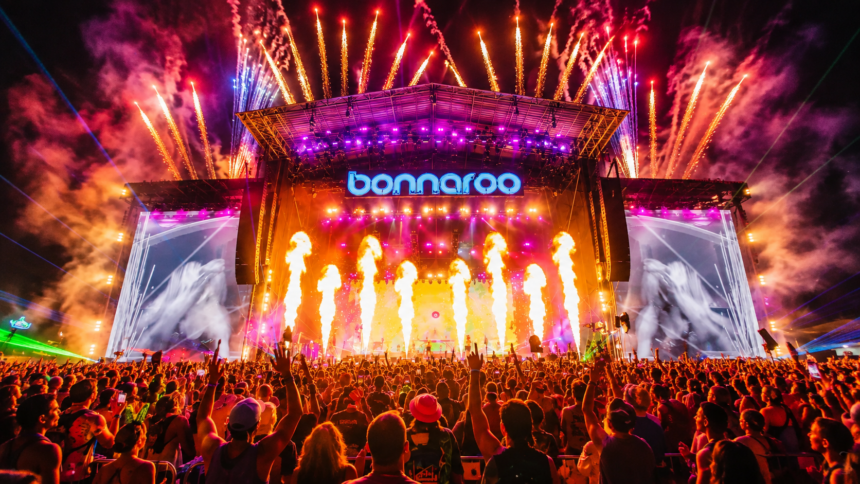 The Bonnaroo main stage lights up with fireworks, flames, and lasers over a massive crowd at night, as the festival announces it will take 2027 off.
