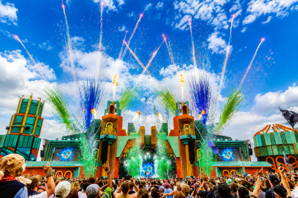 Boomtown's elaborate main stage erupts with fireworks and flames over a packed crowd, from the festival Luke Mitchell built.
