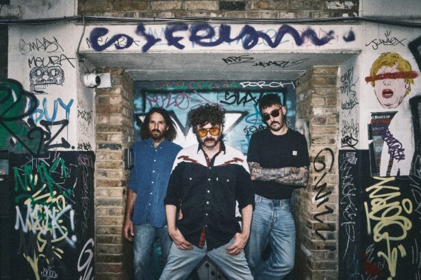 London trio Dead Horse pose in a graffiti-covered doorway, promoting their single 'I Would Die' from debut album 'Caught The Nonsense.'