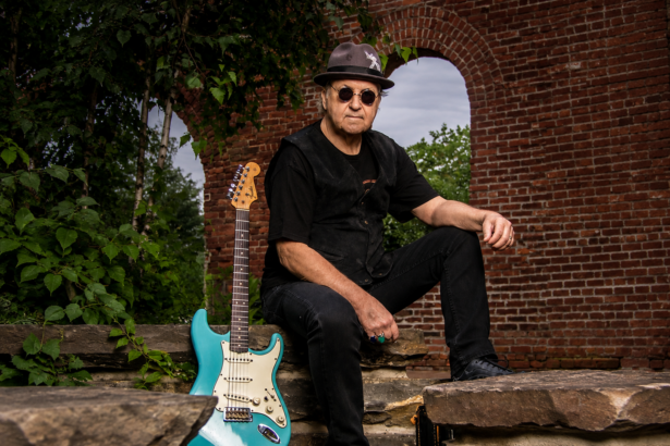 DownTown Mystic frontman Robert Allen poses with his turquoise Fender Stratocaster against a rustic brick archway, promoting the roots-rock EP 'Mystic Highway Road Trip.'