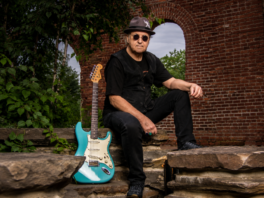 DownTown Mystic frontman Robert Allen poses with his turquoise Fender Stratocaster against a rustic brick archway, promoting the roots-rock EP 'Mystic Highway Road Trip.'