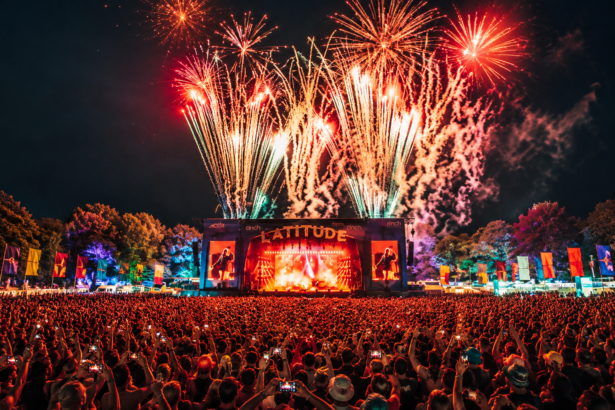 Fireworks erupt over the main stage at Latitude Festival's Henham Park as a massive crowd holds up phones during a headline set at night.