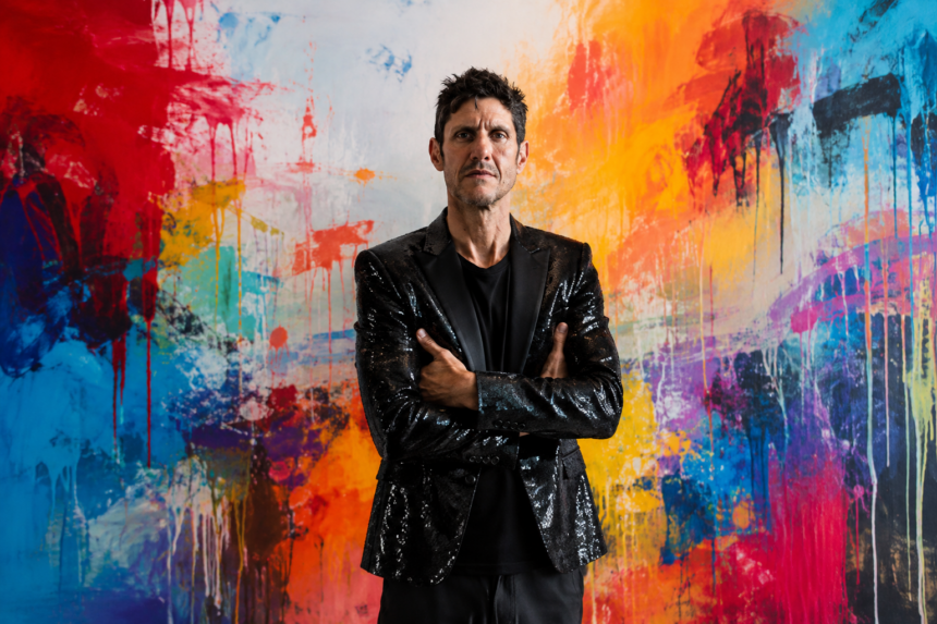 Mike D stands with arms crossed in a black sequined blazer against a vividly paint-splattered abstract backdrop, promoting his debut solo album 'Thank You' and single 'Crypto.'